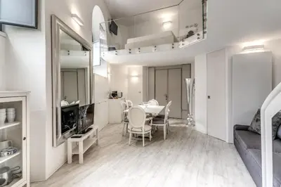 a dining room and living room with a table and chairs at Elegant flat in the Historic Rome near Colosseum! in Rome