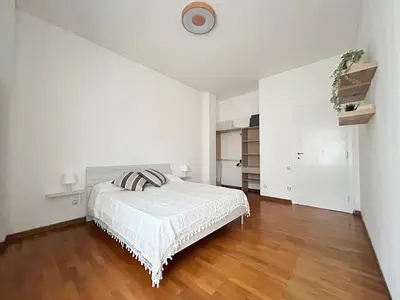 a white bedroom with a bed and a wooden floor at 5Piano Ascensore Near Vaticano Ideale per Famiglie in Rome