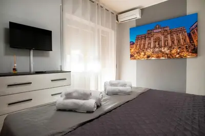 a bedroom with a bed with two chairs and a tv at Appartamento a 2 passi da San Pietro in Rome