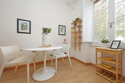 a dining room with a white table and chairs at San Pietros Flat by DomusDimore in Rome