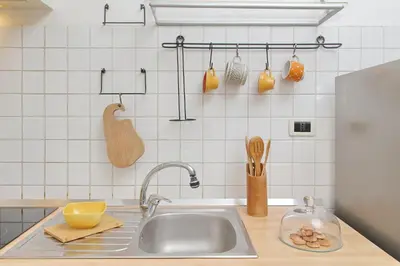 a kitchen with a sink and a counter with utensils at San Pietros Flat by DomusDimore in Rome