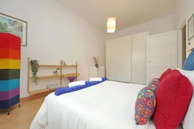 a bedroom with a white bed with colorful pillows at San Pietros Flat by DomusDimore in Rome