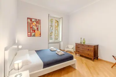 a bedroom with a bed and a dresser and a window at Contemporary Flat in Trastevere in Rome