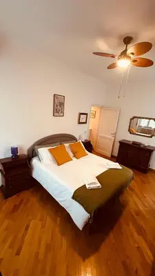a bedroom with a large bed with a ceiling fan at Pamphili Apartment in Rome