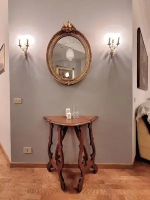 a table with a mirror on a wall at Pamphili Apartment in Rome