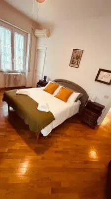 a bedroom with a large bed with white sheets and yellow pillows at Pamphili Apartment in Rome