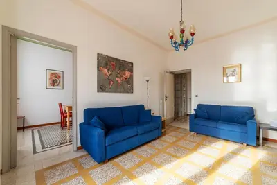 a living room with two blue couches and a chandelier at GuestHost - Bright and roomy apartment in Flaminio district in Rome