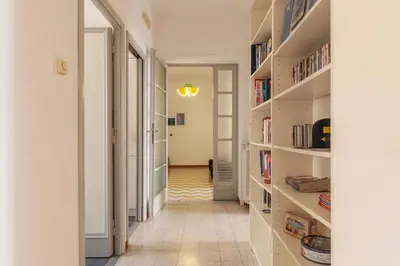a hallway with bookshelves and a hallway with a hallway at GuestHost - Bright and roomy apartment in Flaminio district in Rome