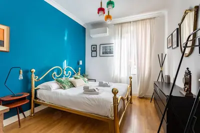 a blue bedroom with a bed and a television at iFlat Charming Vintage Apartment in Esquilino in Rome