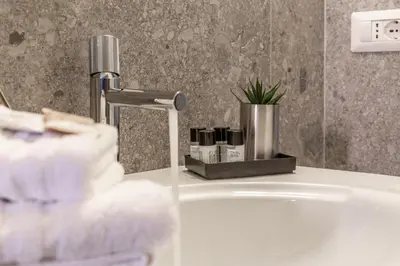 a bathroom sink with a faucet and a bath tub at iFlat Charming Vintage Apartment in Esquilino in Rome