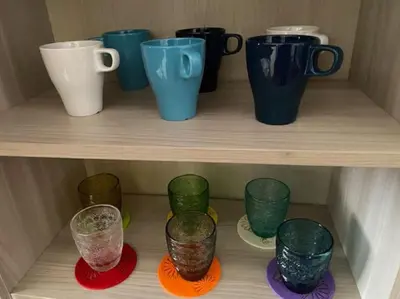 a group of cups on a wooden shelf at Cin Cin ROMA Centro in Rome