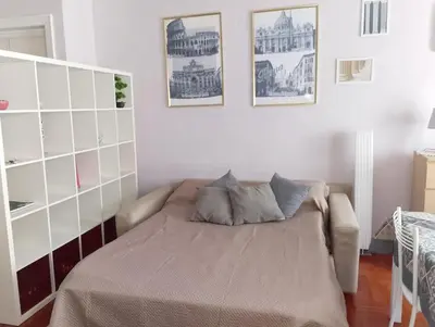 a bedroom with a bed and a white wall at Cin Cin ROMA Centro in Rome