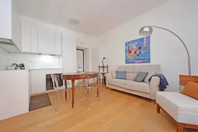 a living room with a couch a table and a kitchen at YCH-Delightful flat near San Giovanni in Rome