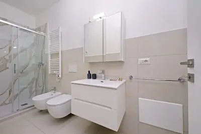 a white bathroom with a toilet and a sink at YCH-Delightful flat near San Giovanni in Rome
