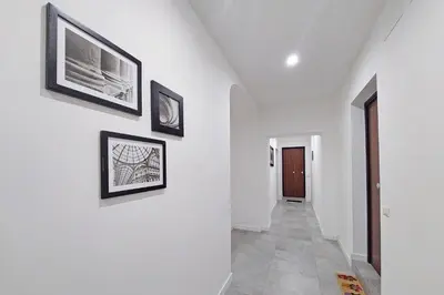 a hallway with three framed pictures on the wall at YCH-Delightful flat near San Giovanni in Rome