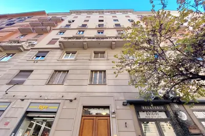a tall white building with a brown door at YCH-Delightful flat near San Giovanni in Rome