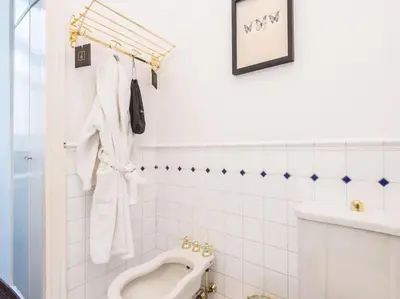 a white bathroom with a urinal and a sink at Luxury Spanish Steps Terrace in Rome