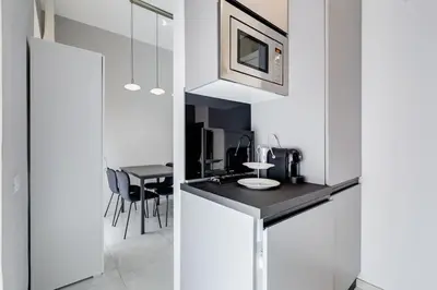 a kitchen with white walls and a black counter top at Vatican Escape in Rome