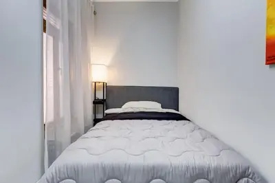 a white bed in a white bedroom with a window at Vatican Escape in Rome