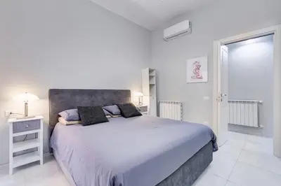 a white bedroom with a large bed and a window at Vatican Escape in Rome