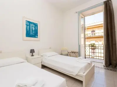 two beds in a white room with a window at Vatican Comfortable Sunny Apartment in Rome