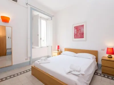 a white bedroom with a large bed and a mirror at Vatican Comfortable Sunny Apartment in Rome