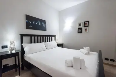a bedroom with a bed with white sheets and towels at Elegantis Purificazione Suite Apartment in Rome
