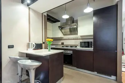 a kitchen with brown cabinets and a white counter top at Elegantis Purificazione Suite Apartment in Rome