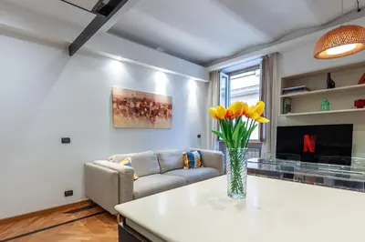 a living room with a couch and a vase of flowers at Elegantis Purificazione Suite Apartment in Rome