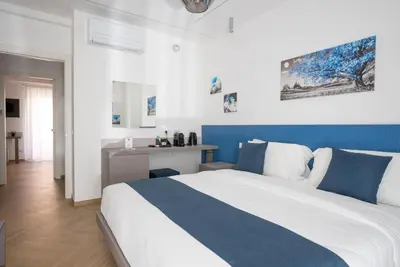 a bedroom with a blue and white bed and a desk at Hezio Guest House in Rome