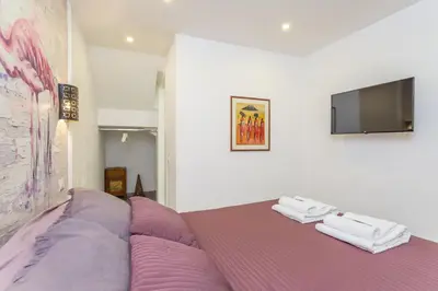 a bedroom with a purple bed and a flat screen tv at Spacious 4 BDR with Parking in Rome