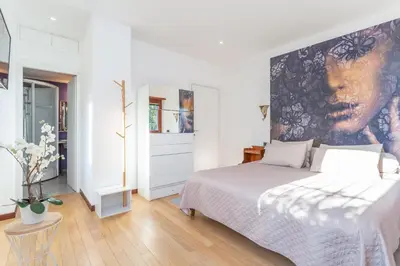 a bedroom with a bed and a painting on the wall at Spacious 4 BDR with Parking in Rome