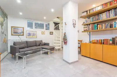 a living room with a couch and a book shelf at Spacious 4 BDR with Parking in Rome