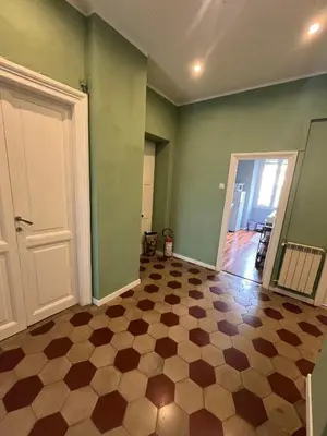 an empty room with green walls and a checkered floor at Appartamento Viale Trastevere in Rome