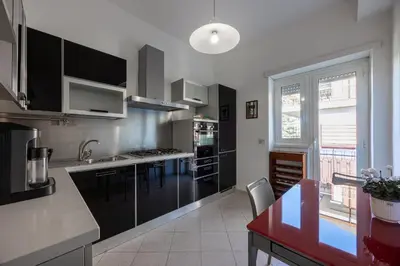 a kitchen with stainless steel appliances and a red table at Vaticano84 Gemelli in Rome