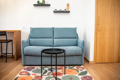 a blue couch sitting in a living room with a rug at Appartamento tra Piramide e Garbatella - Urbe Romana in Rome