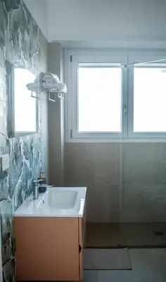 a bathroom with a sink and two windows at Appartamento tra Piramide e Garbatella - Urbe Romana in Rome