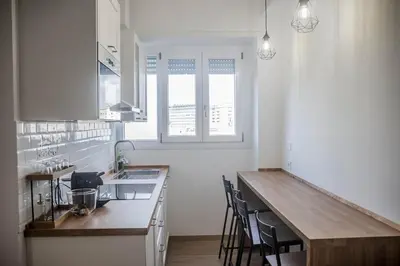 a kitchen with a counter top and chairs in it at Appartamento tra Piramide e Garbatella - Urbe Romana in Rome