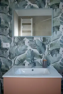 a bathroom with a sink and a leafy wallpaper at Appartamento tra Piramide e Garbatella - Urbe Romana in Rome