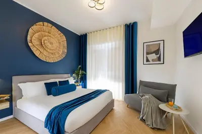 a bedroom with a large bed with blue walls at Tolu Relais in Rome