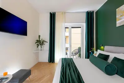 a green and white bedroom with a bed and a couch at Tolu Relais in Rome