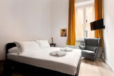 a bedroom with a bed and a chair and a window at Confalonieri Place by Oneup Hospitality in Rome