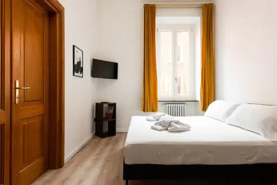 a bedroom with a bed with white sheets and a window at Confalonieri Place by Oneup Hospitality in Rome