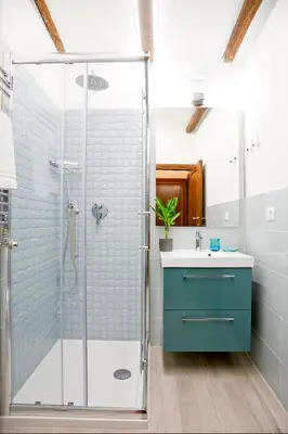 a bathroom with a glass shower and a sink at Monti Suite with charming Terrace in Rome