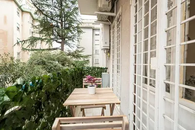 a small table on a balcony with two chairs at MagicHouse 2 Camere 2 Bagni -15 min Colosseo in Rome