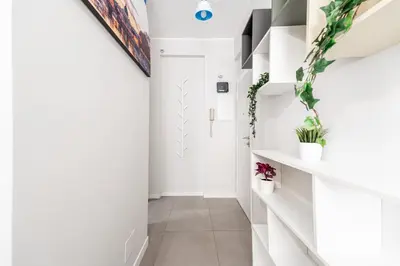 a hallway with white walls and white floors and plants at MagicHouse 2 Camere 2 Bagni -15 min Colosseo in Rome