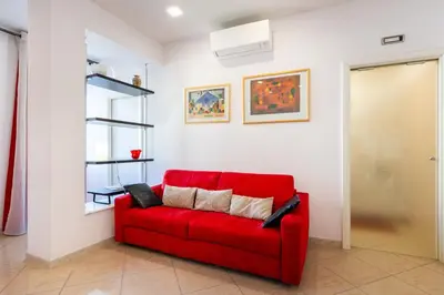 a red couch sitting in a living room at Lungotevere Aventino House by ACS HOLIDAYS in Rome