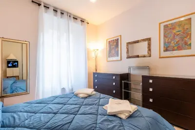 a bedroom with a bed and a dresser and a mirror at Lungotevere Aventino House by ACS HOLIDAYS in Rome