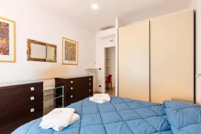 a bedroom with a blue bed and a mirror at Lungotevere Aventino House by ACS HOLIDAYS in Rome