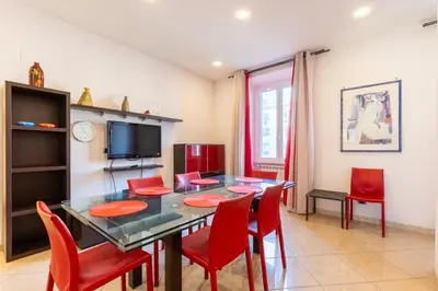 a dining room with a table and red chairs at Lungotevere Aventino House by ACS HOLIDAYS in Rome